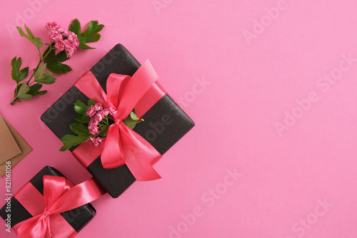 Black craft gift boxes with hawthorn flowers and pink ribbons. Horizontal, space for your text.