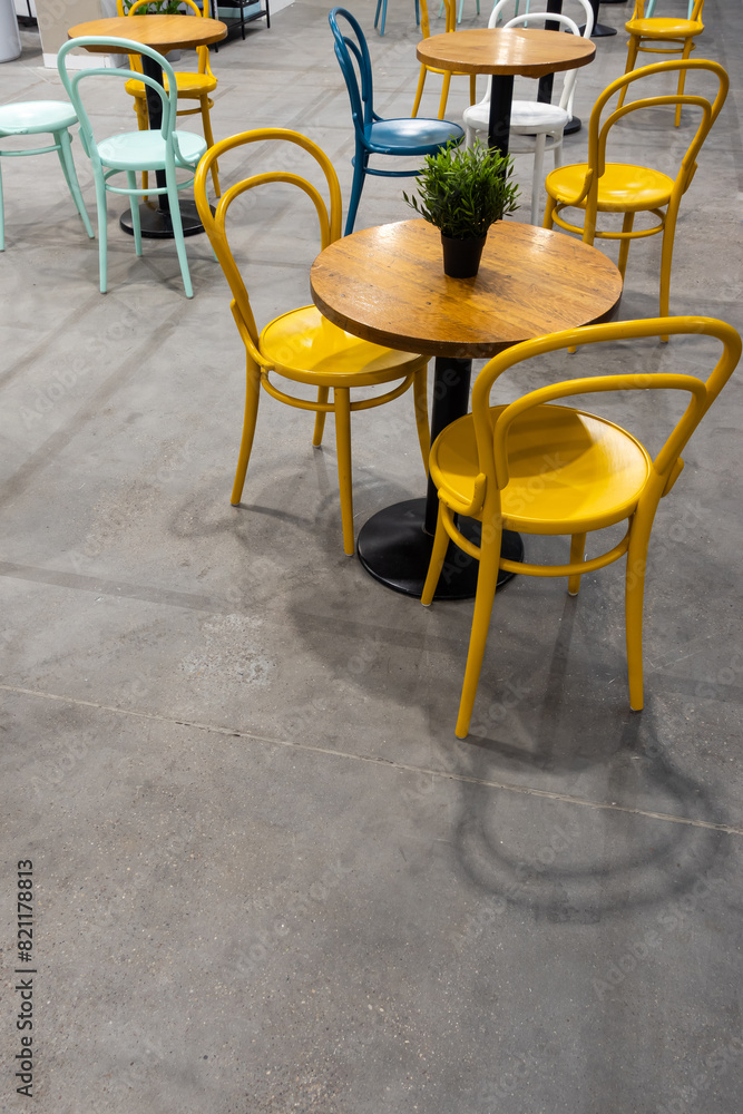 Colorful wooden chairs and tables in a public restaurant. Public places for eating quick meals.