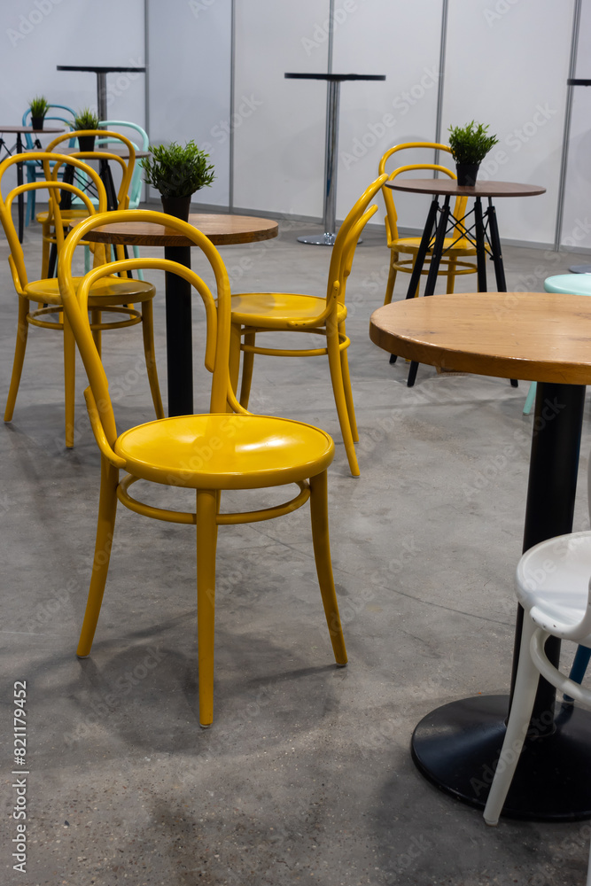 Colorful wooden chairs and tables in a public restaurant. Public places for eating quick meals.