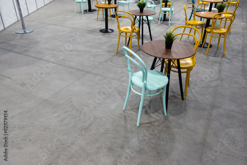 Colorful wooden chairs and tables in a public restaurant. Public places for eating quick meals.