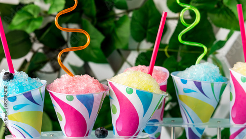 A close up of colourful snow cones with crazy straws, ready for sharing.