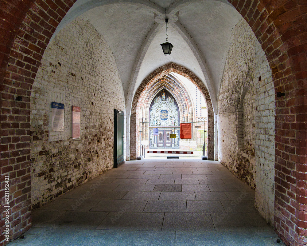 Fototapeta premium Blick durch den gotischen Gewölbegang im Rathaus am Alten Markt in Stralsund, historische Architektur der Backsteingotik, Hanse-Tradition, UNESCO-Welterbe, Mecklenburg-Vorpommern, Deutschland