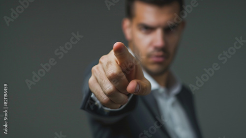 close up of businessman pointing finger on a grey background with copy space for your text