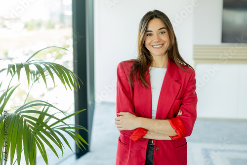 Confident woman smiling in bright office space during daytime photo