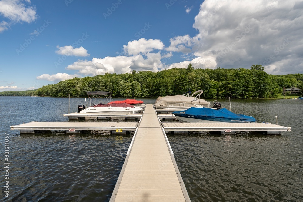 Sun shines on a tranquil dock while boats rock silently in the rippling water of Deep Creek Lake in rural Garrett County, Maryland, USA. Sun shines on a tranquil dock while boats rock silently in the rippling water of Deep Creek Lake in rural Garrett County, Maryland, USA.