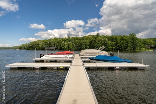 Sun shines on a tranquil dock while boats rock silently in the rippling water of Deep Creek Lake in rural Garrett County, Maryland, USA.
