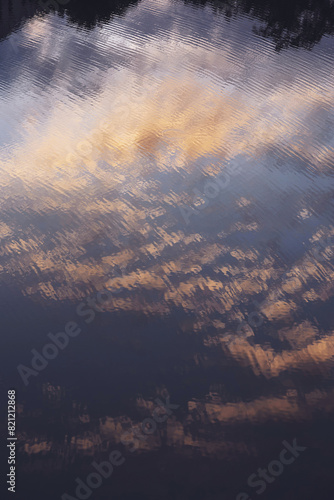 View of the lake surface with the sky reflection. Sunset Sky Ripple on The Lake Surface. 