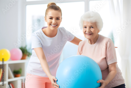 Senior Caucasian woman exercising with her physiotherapist and swiss ball © ZayWin