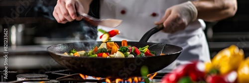 A chef is flamboyantly tossing a colorful mix of vegetables in a pan over an open flame