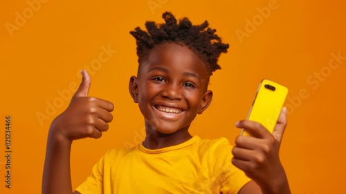Boy with Smartphone Giving Thumbs Up photo