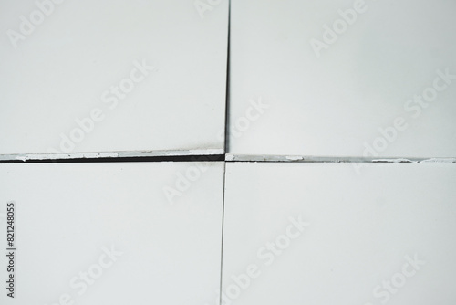 Ceramic tiles floor cracked and broken from concrete inflate in house or office building.House problem renovation, repair service and construction concept.Close up.