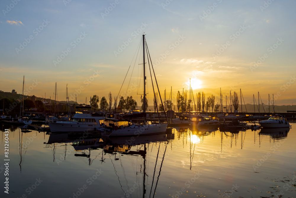 Sailboats moored in the Sillery marina during a golden hour spring sunrise, Quebec City, Quebec, Canada