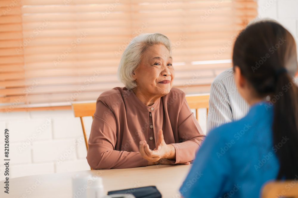 Obraz premium Happy Senior Asian Woman Receives Medical Care at Home, Doctor or Caregiver Nurse Provide Support Assistance, Enhancing Healthcare Services for Elderly Patients Retirement
