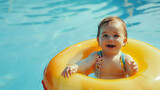 A baby with a yellow inflatable circle is having fun swimming in a pool. a cute little girl on vacation in the pool or water park.