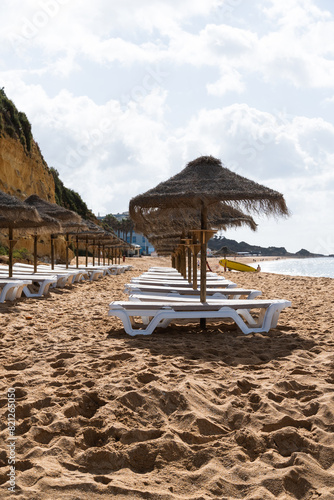 Straw chairs and umbrella. Praia do Peneco beach  Albufeira  Algarve  Portugal. Praia dos Pescadores beach. Fishermen  sunny day