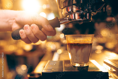Professional Barista Prepares Fresh Cappuccino in a Busy Cafe: Closeup of Hands Skillfully Using Espresso Machine, Emphasizing the Art of Hot Beverage Making and Quality Service in a Cafeteria photo