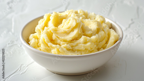 Mashed potatoes in a white bowl placed on a white background.