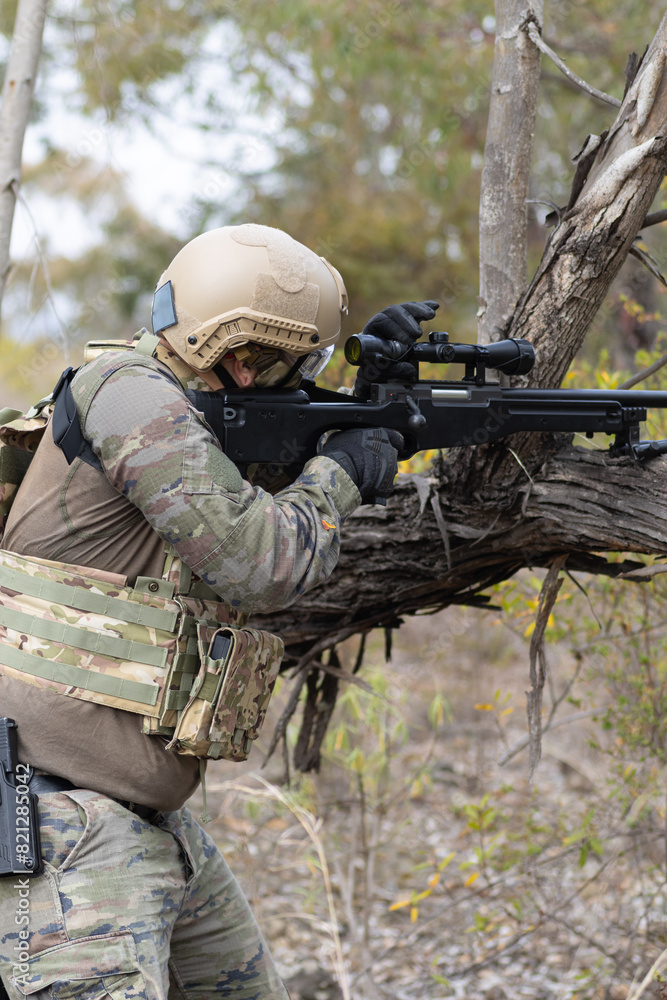 Fototapeta premium Soldier airsoft player dressed in camouflage uniform wielding a sniper rifle
