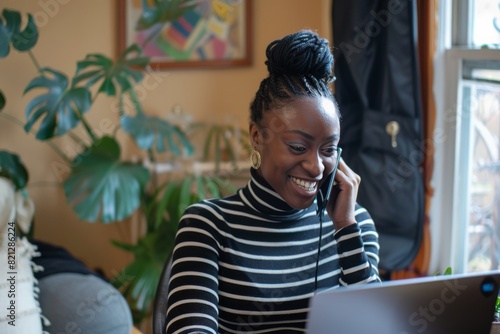 Woman Sitting at Desk Talking on Cell Phone