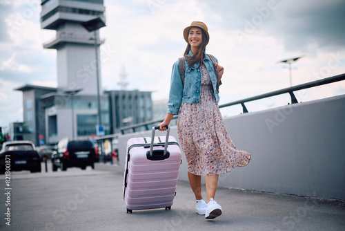 Quadro em tela Happy female traveler with suitcase arriving at  airport.