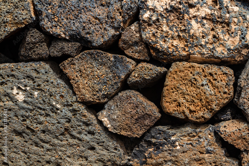 Close-up. Background. Wall of large and small natural volcanic stones. Close-up. Background. Wall of large and small natural volcanic stones.