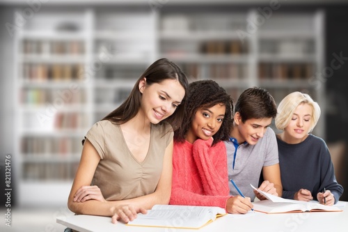 Happy group of young students studying in library