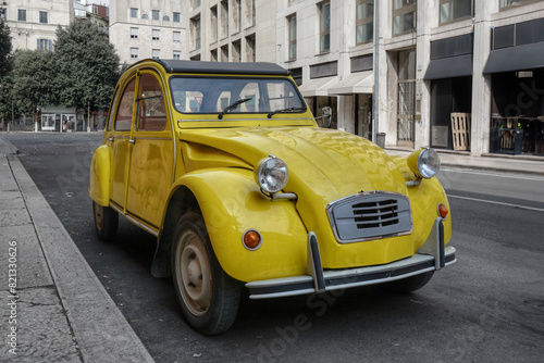 A classic old yellow French car parked on an empty street in the city of Verona  © Felix Tchvertkin