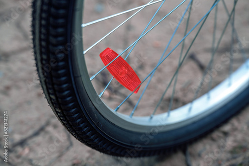 Red reflector attached to bicycle wheel spokes