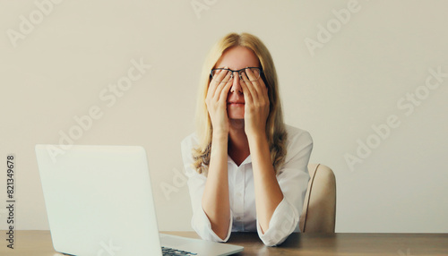 Quadro em tela Tired overworked woman employee suffering from headache, rubbing eyes, working w