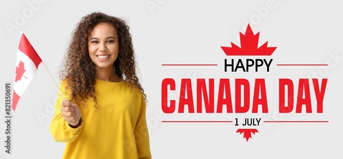 Happy young African-American woman with Canadian flag on light background. Banner for Canada Day photo