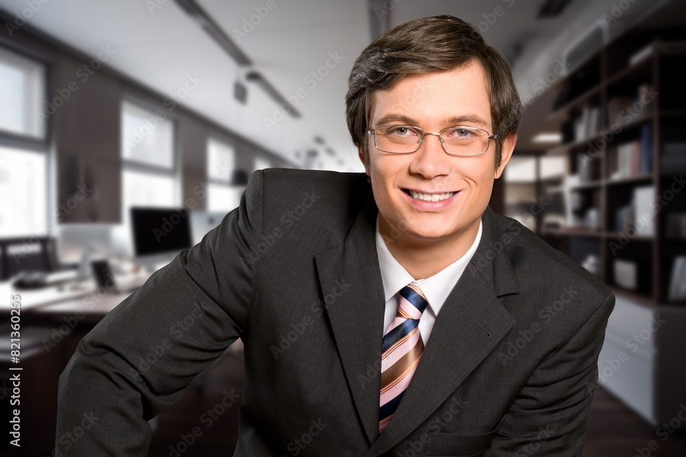 Portrait of successful businessman in suit working inside office building Portrait of successful businessman in suit working inside office building