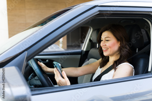 Woman smiling while using smartphone while driving, emphasizing the dangers of distracted driving