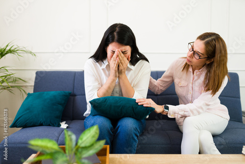 Woman psychologist offers comfort to a crying patient during a private therapy session, depicting a moment of genuine mental health care