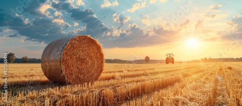 Rural field with hay bales and tractor photo