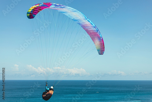 Paraglider flies in front of the ocean