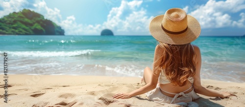 Woman in straw hat sitting on beach photo
