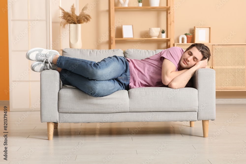 Weary young man sleeping on sofa at home Weary young man sleeping on sofa at home
