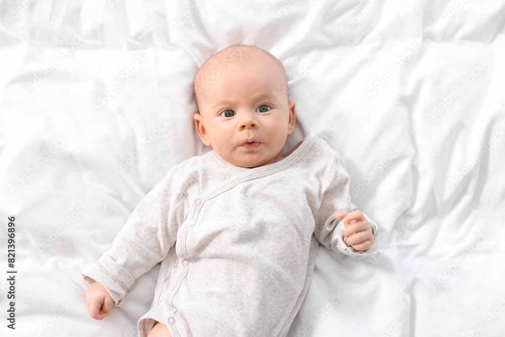 Cute little baby lying on white sheets, top view Cute little baby lying on white sheets, top view