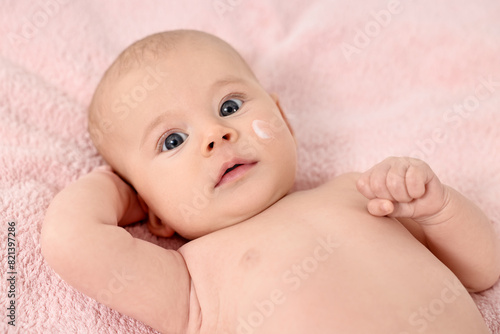 Cute little baby with cream on face on pink blanket, above view
