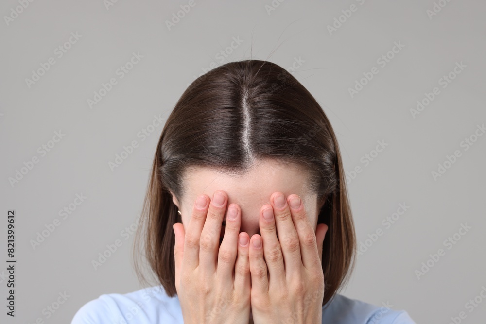 Woman suffering from hair loss problem on grey background, closeup Woman suffering from hair loss problem on grey background, closeup