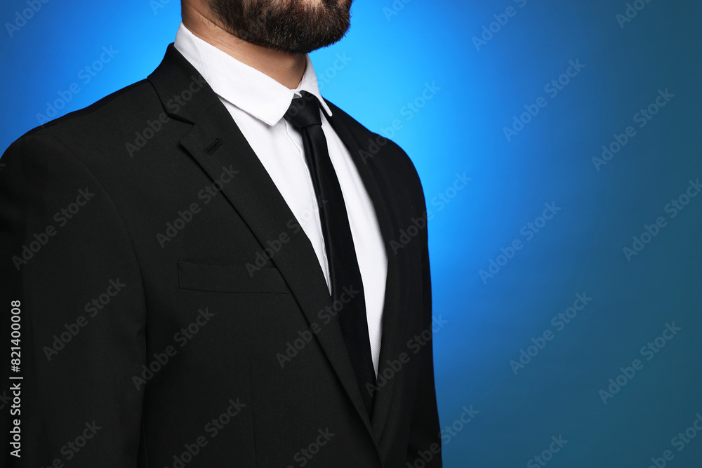 Businessman in suit and necktie on blue background, closeup. Space for text Businessman in suit and necktie on blue background, closeup. Space for text