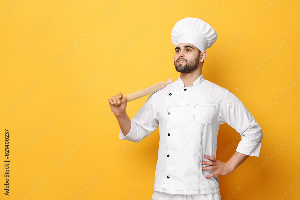 Professional chef with rolling pin on yellow background. Space for text Professional chef with rolling pin on yellow background. Space for text