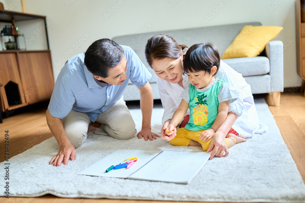 2歳の孫とお絵描きをするシニア夫婦