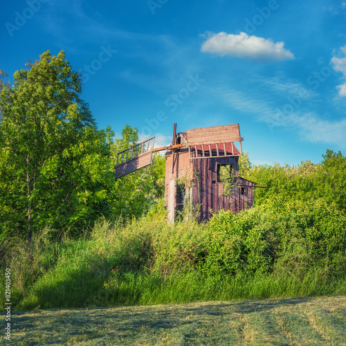 square frame view to rustic abandoned windmill in spring day
