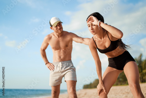 Care and support. Sport lifestyle concept. Young strong man helping his tired girlfriend while jogging