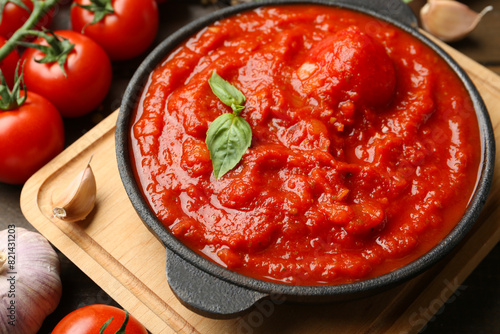 Homemade tomato sauce in bowl and ingredients on table, closeup © New Africa