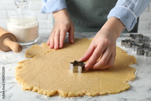 Shortcrust pastry. Woman making cookies with cutter at white marble table, closeup