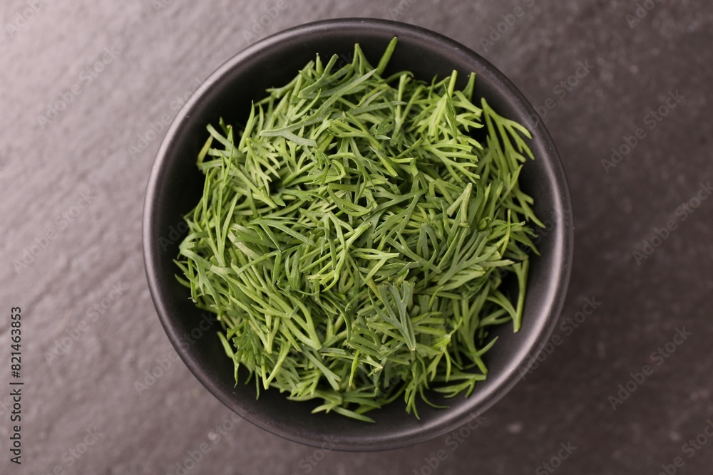 Fresh cut dill in bowl on dark table, top view Fresh cut dill in bowl on dark table, top view