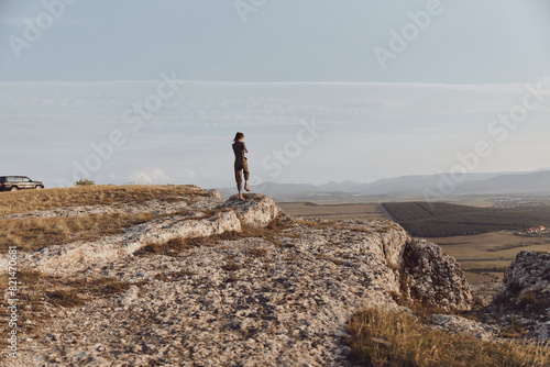 Man standing on top of hill admiring majestic valley and mountains in front of him  wanderlust travel concept
