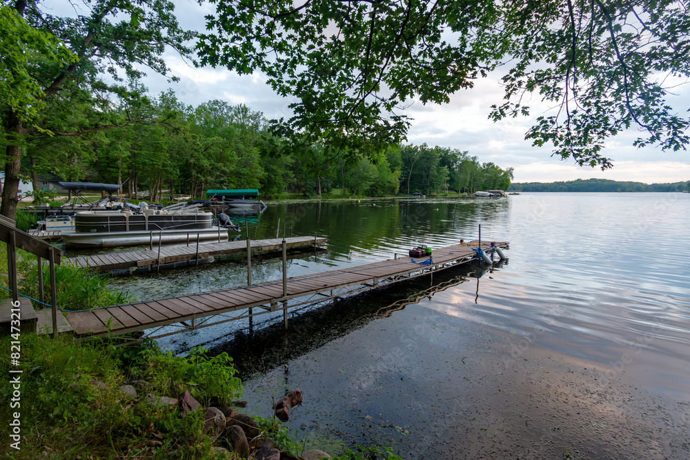 Looking out onto a Wisconsin northwoods lake as the last rays of sunlight begin to fade. Many pontoon boats have returned from fishing for the evening. Looking out onto a Wisconsin northwoods lake as the last rays of sunlight begin to fade. Many pontoon boats have returned from fishing for the evening.